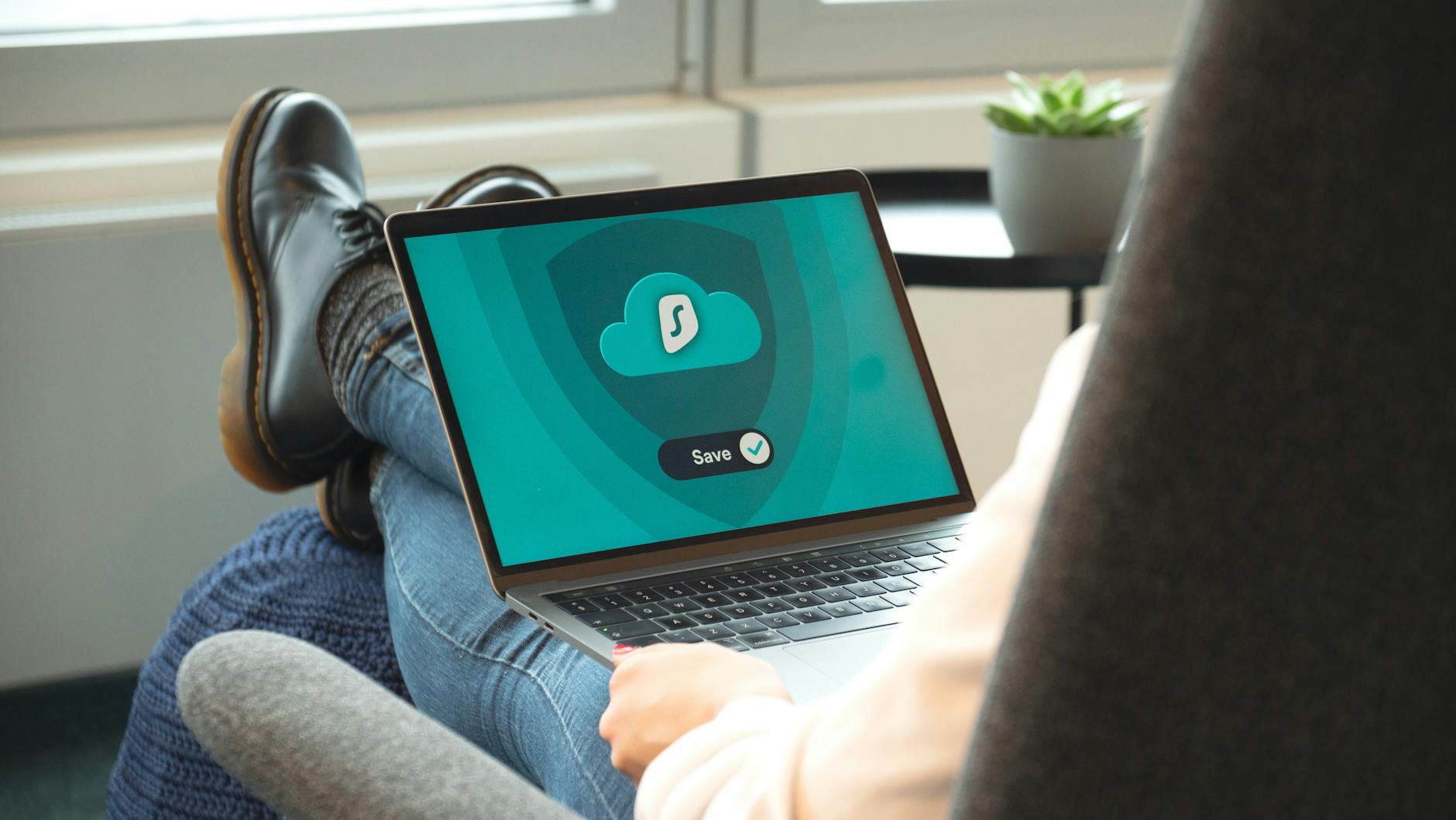 Osoba w butach odpoczywa z laptopem pokazującym ekran włączonego VPN