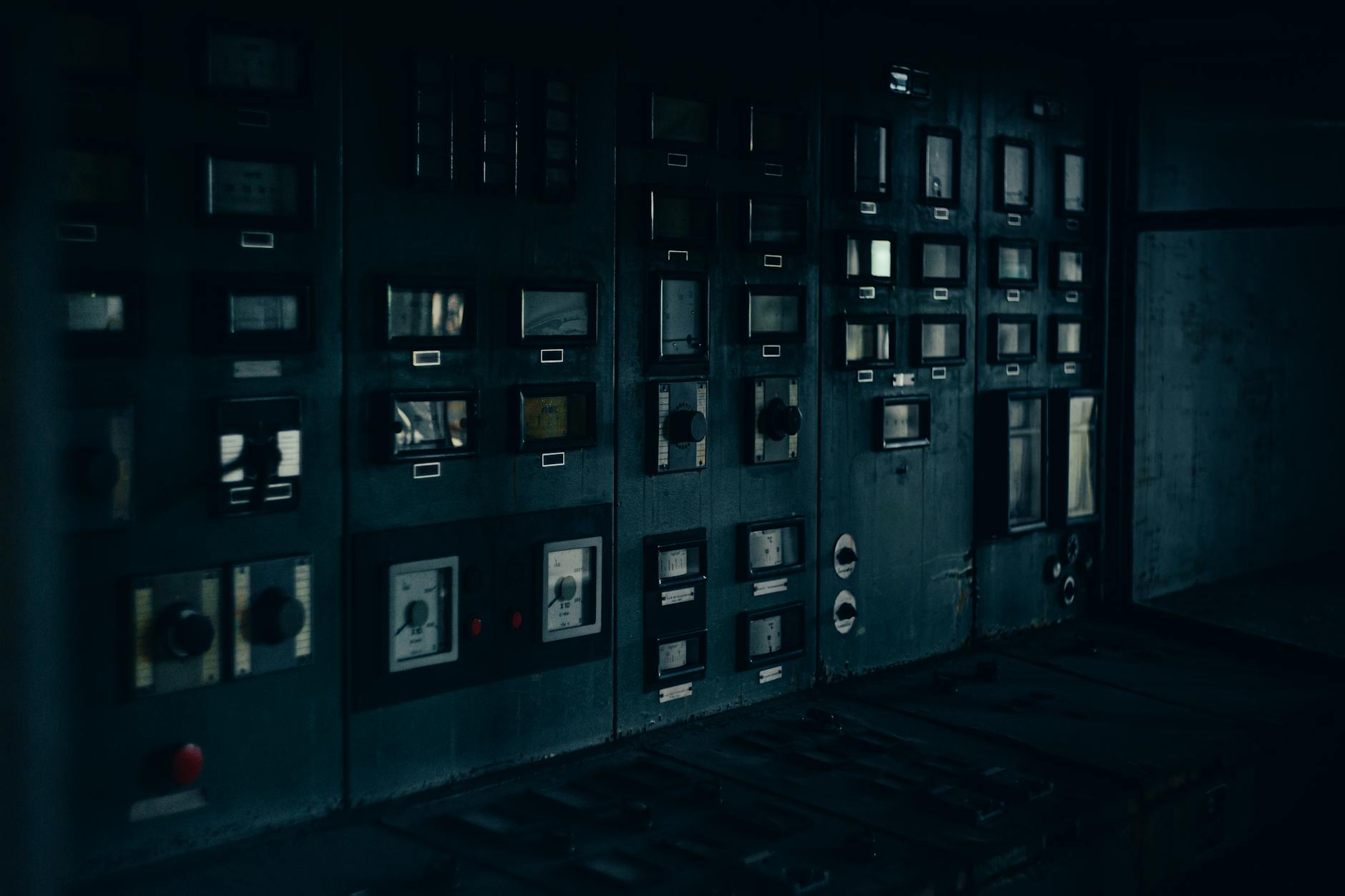 Retro panel sterowania przemysłowego z zegarami w ciemnym pomieszczeniu