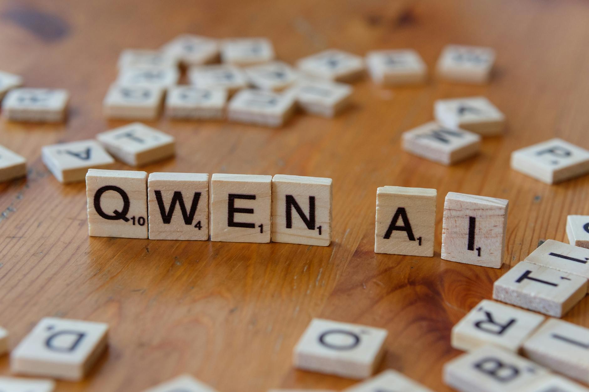 Klocki scrabble z napisem Qwen AI na drewnianym blacie