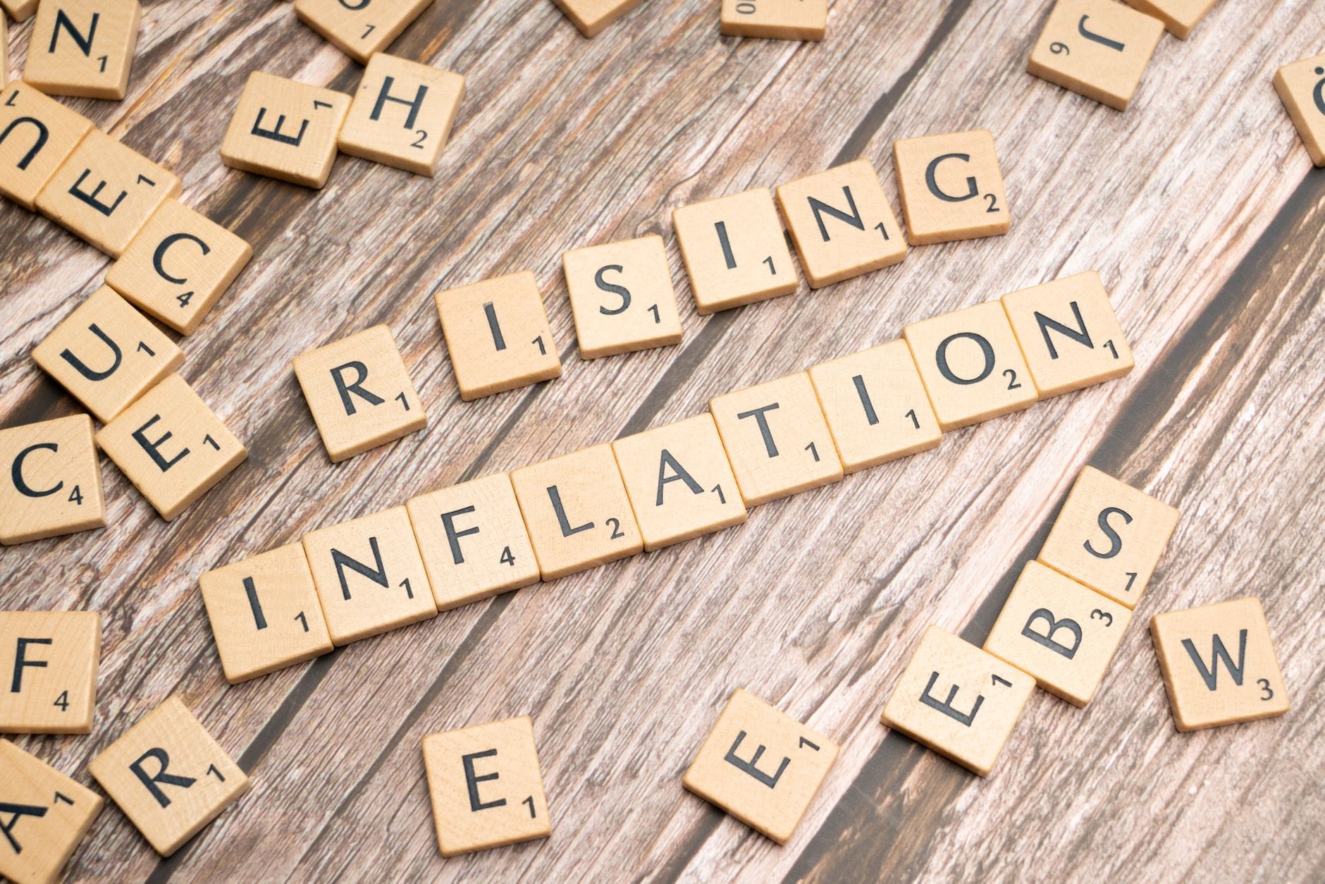 Drewniane kostki z napisem rising inflation na stole
