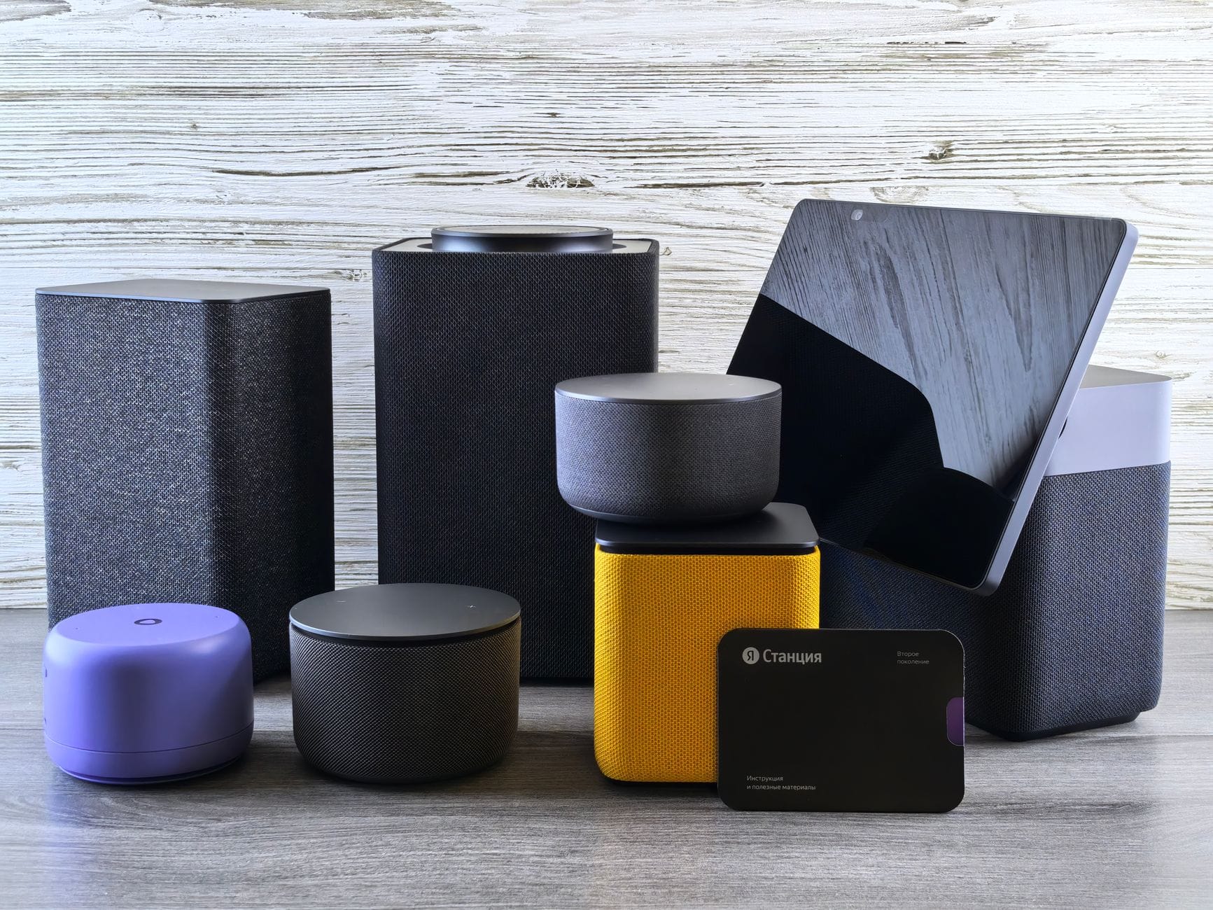 Różne głośniki smart home i tablet leżące na drewnianym blacie
