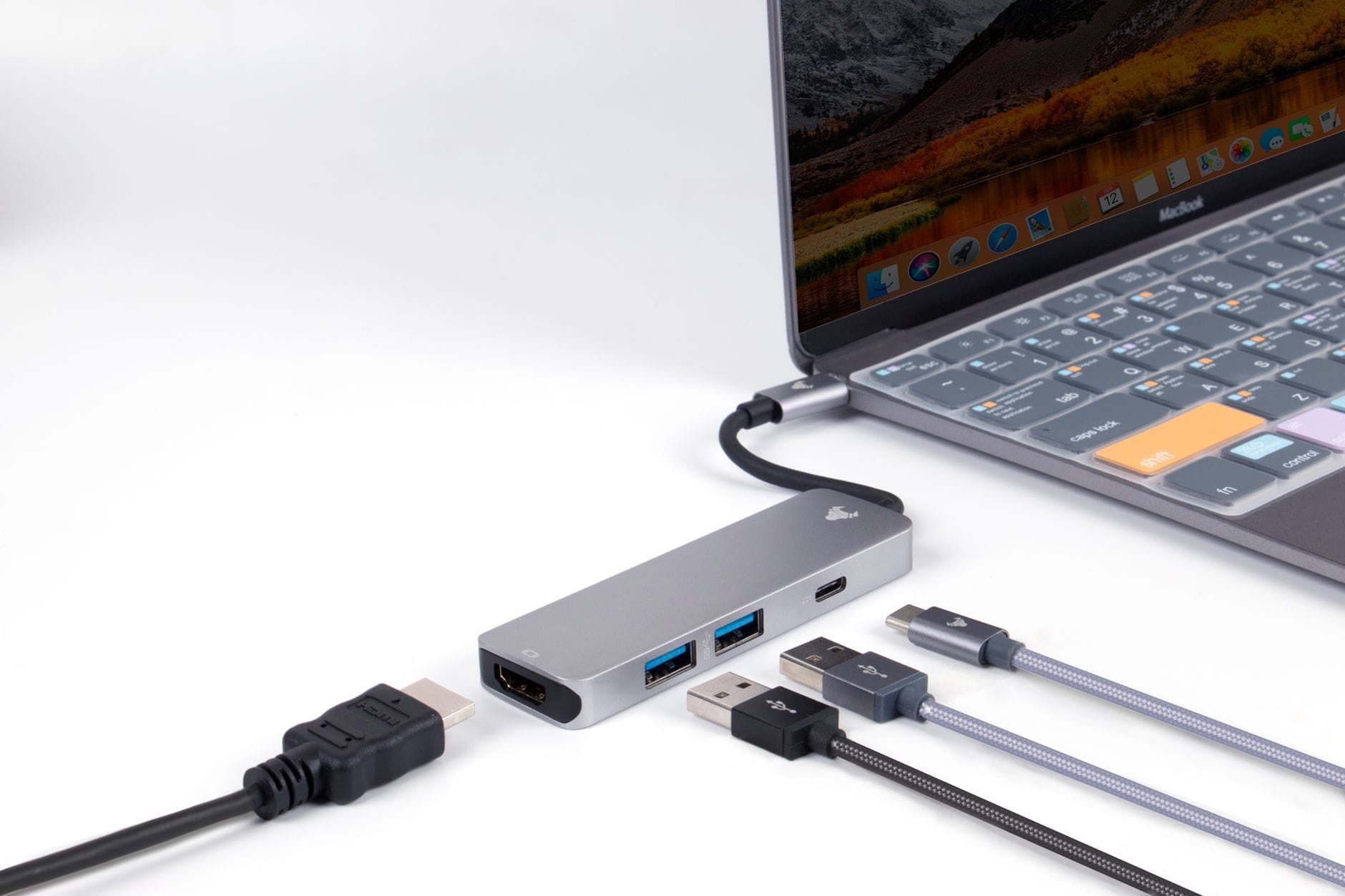 Zbliżenie na hub USB‑C podłączony do laptopa na białym blacie