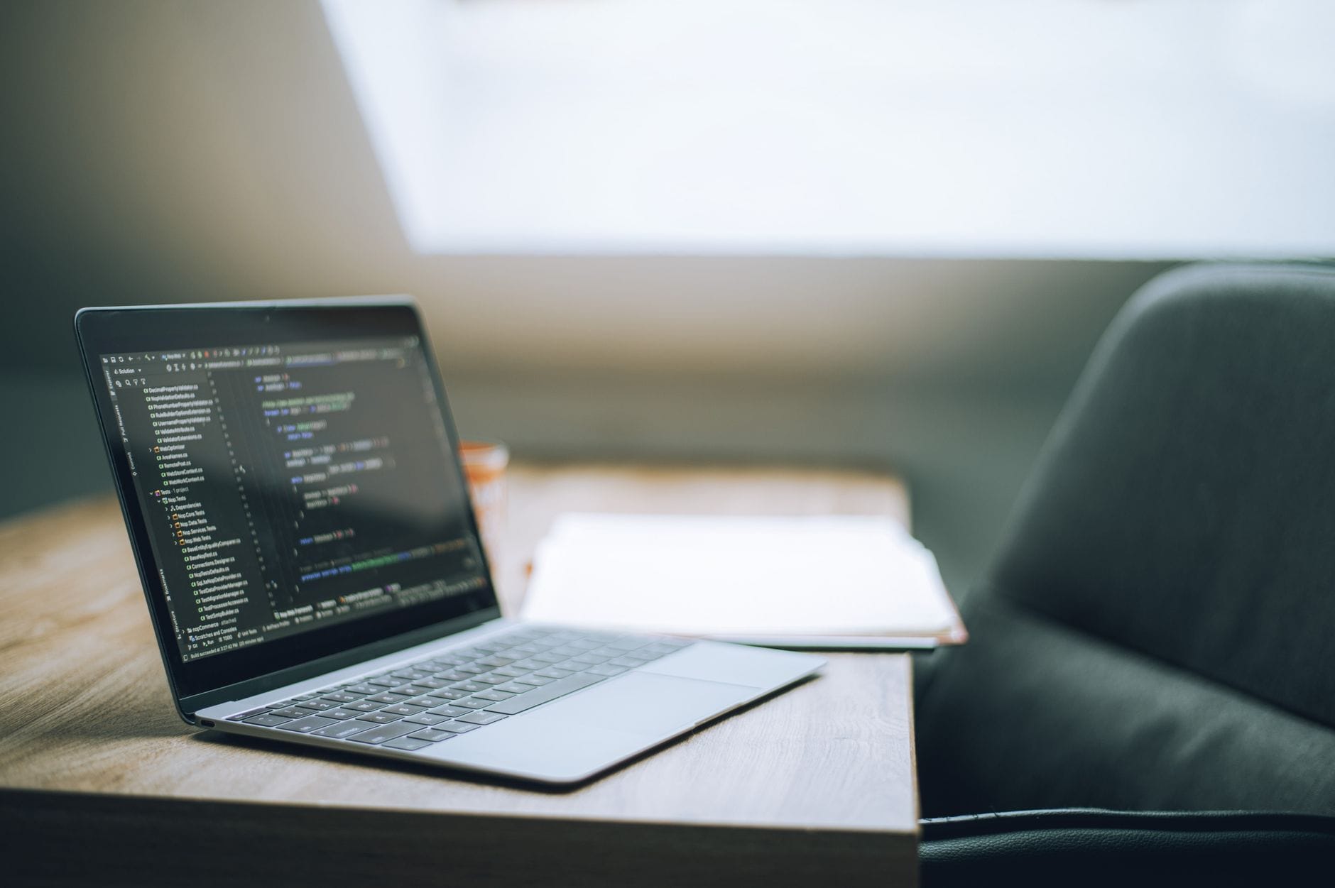 Jak uniknąć wypalenia zawodowego w IT praktyczne strategie dla programistów i inżynierów infrastruktury Laptop z wyświetlonym kodem na biurku w jasnym biurze IT