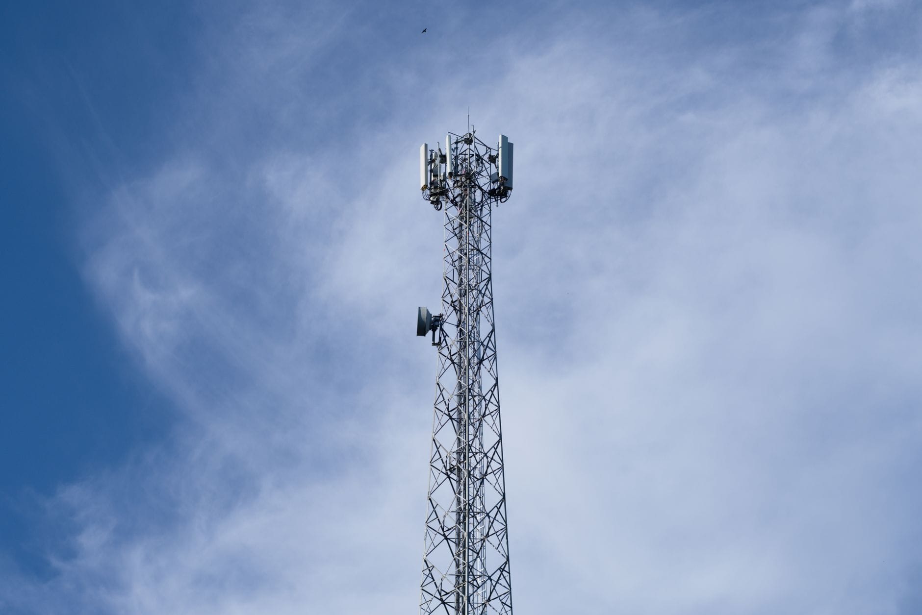 Maszt telekomunikacyjny 5G na tle błękitnego nieba z chmurami