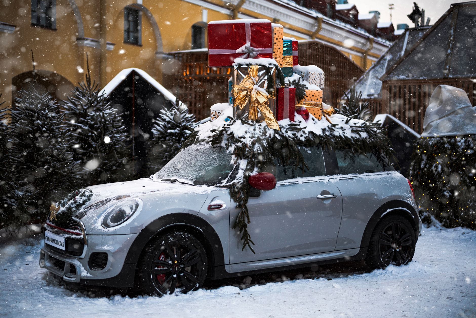 Mini Cooper z prezentami na dachu zaparkowany w ośnieżonym otoczeniu